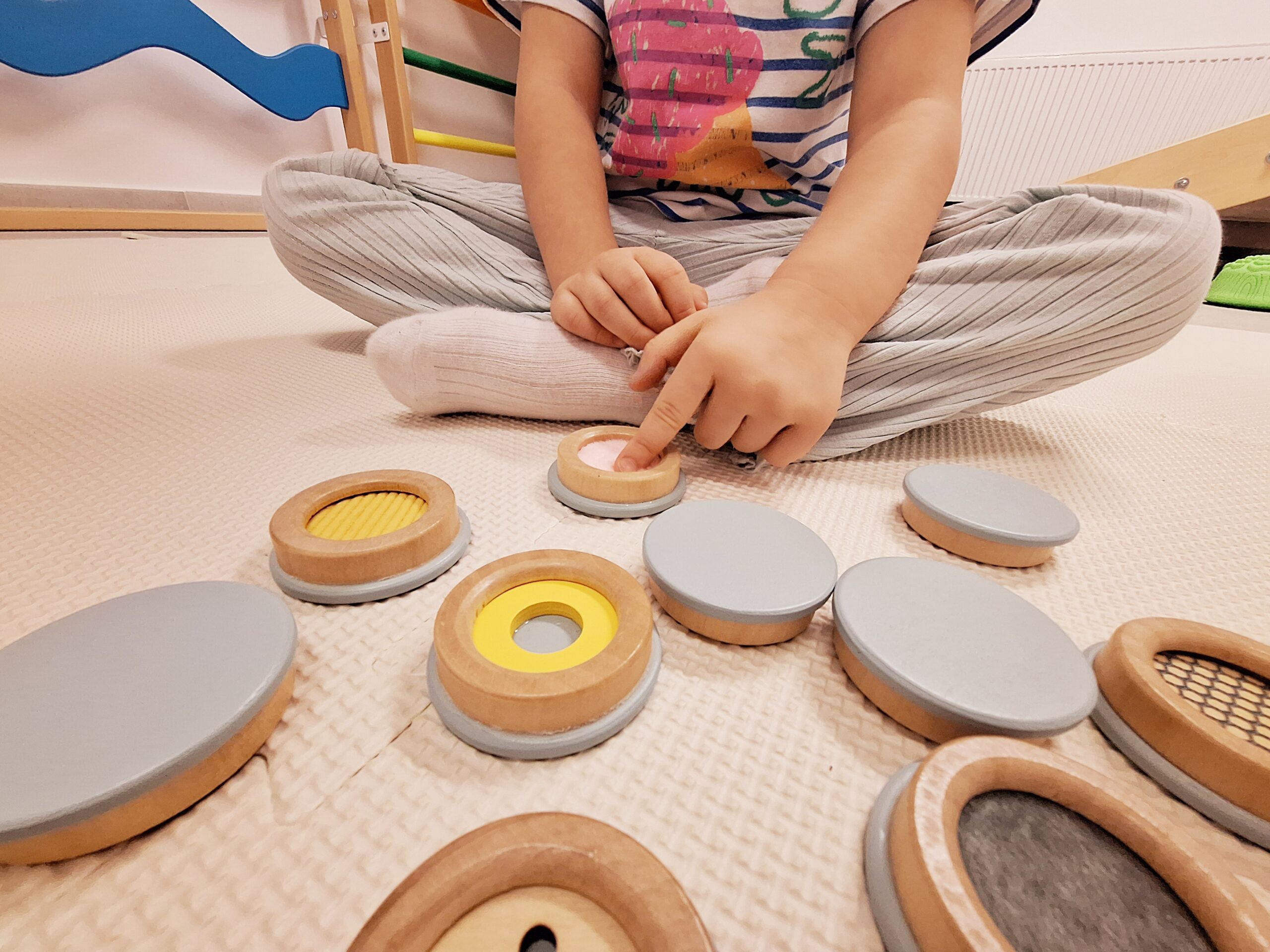 Dziecko wykonujące ćwiczenia wspierające rozwój; terapia integracji sensorycznej pomaga radzić sobie z nadwrażliwością na bodźce.